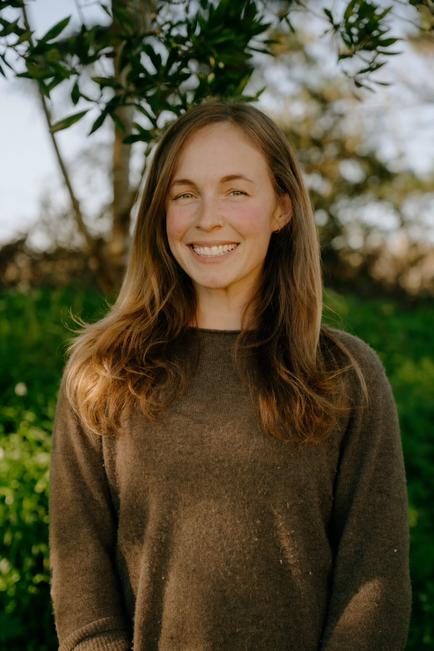 Suzy Marie, founder of Blossom and Root, outdoors among trees